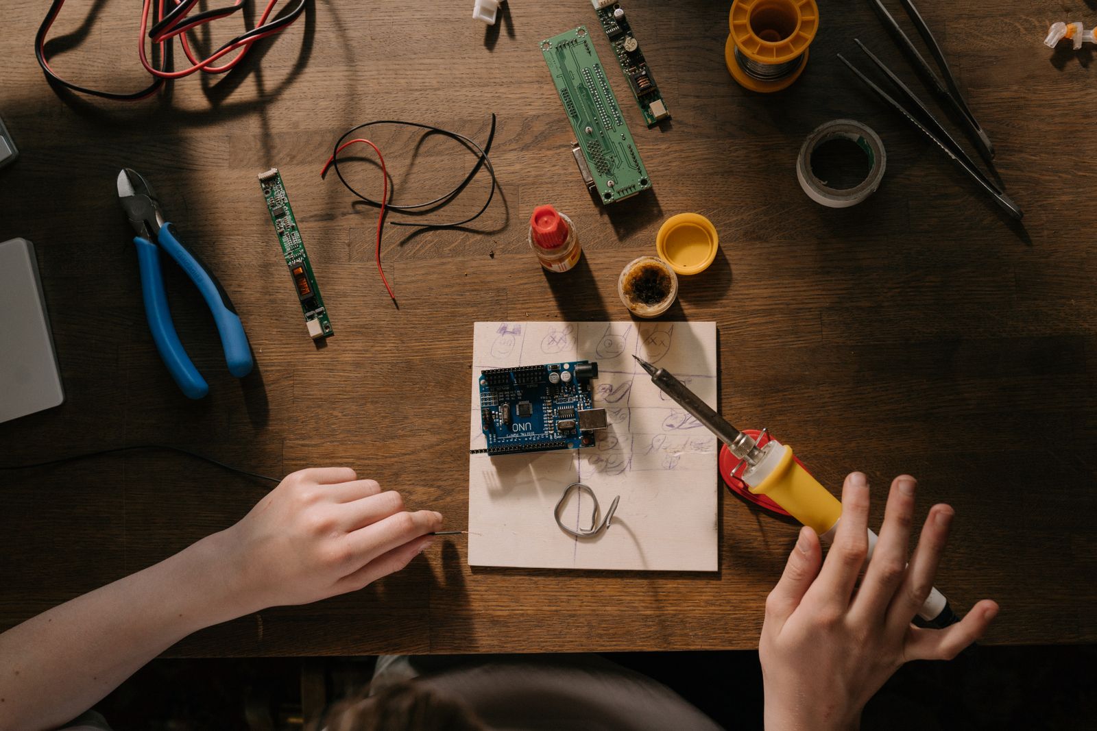 Soldering tools and a circuit board laid out on a workbench