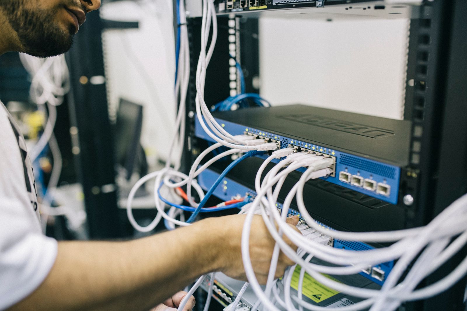 Hands working on network equipment in a rack